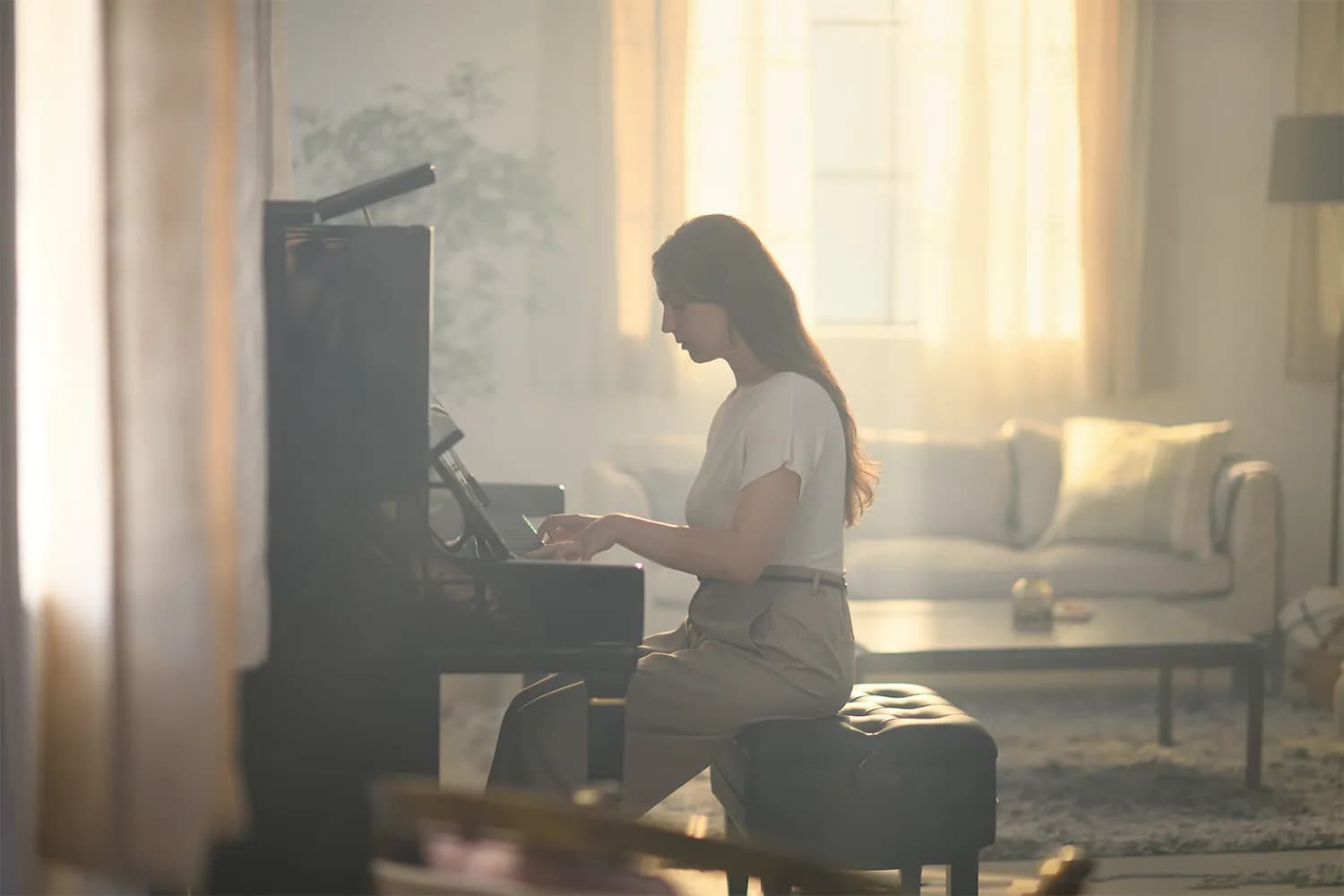 A pianist at a Kawai upright in a sunlit living room
