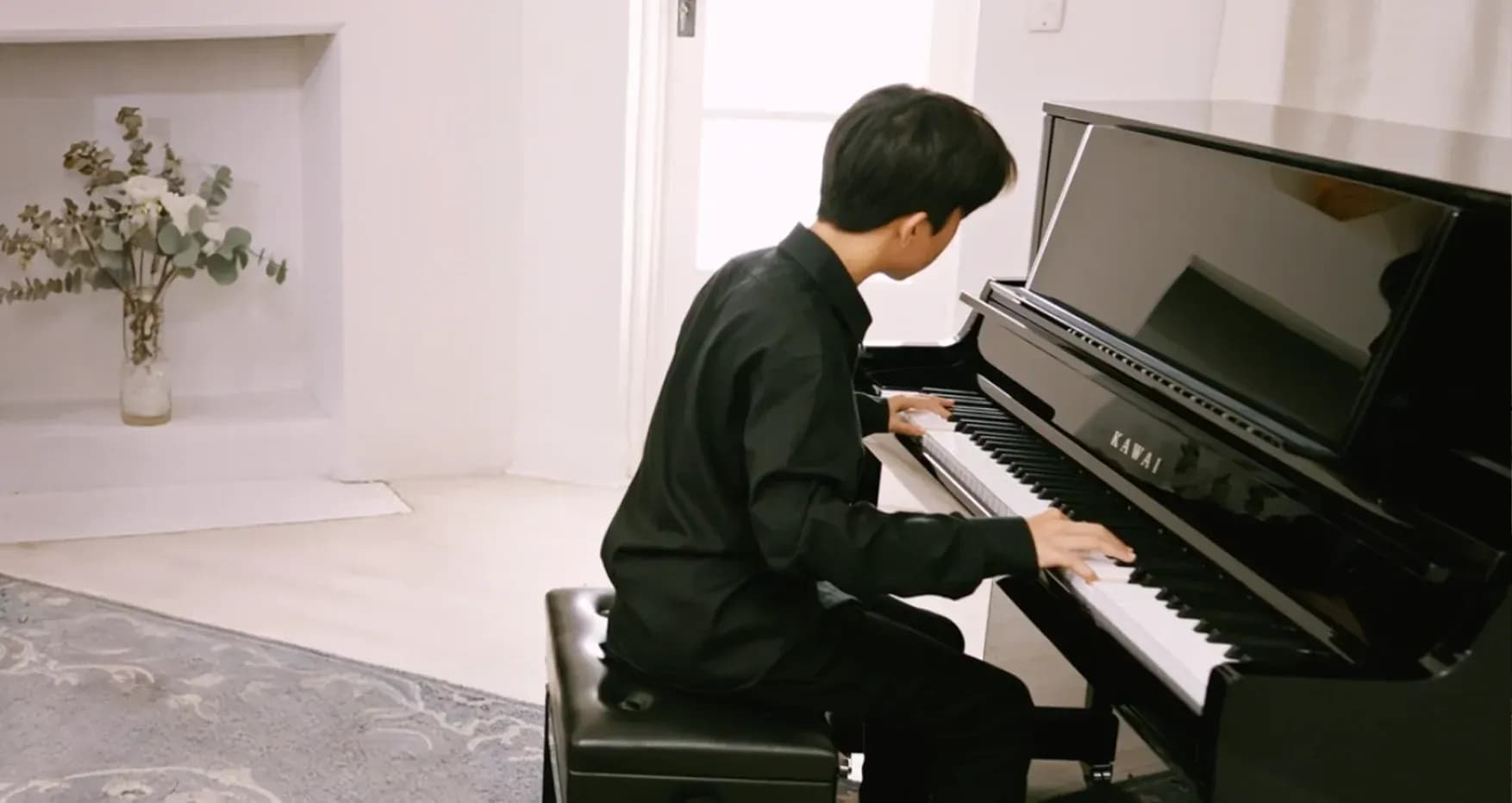 A pianist playing a Kawai K Series professional upright piano