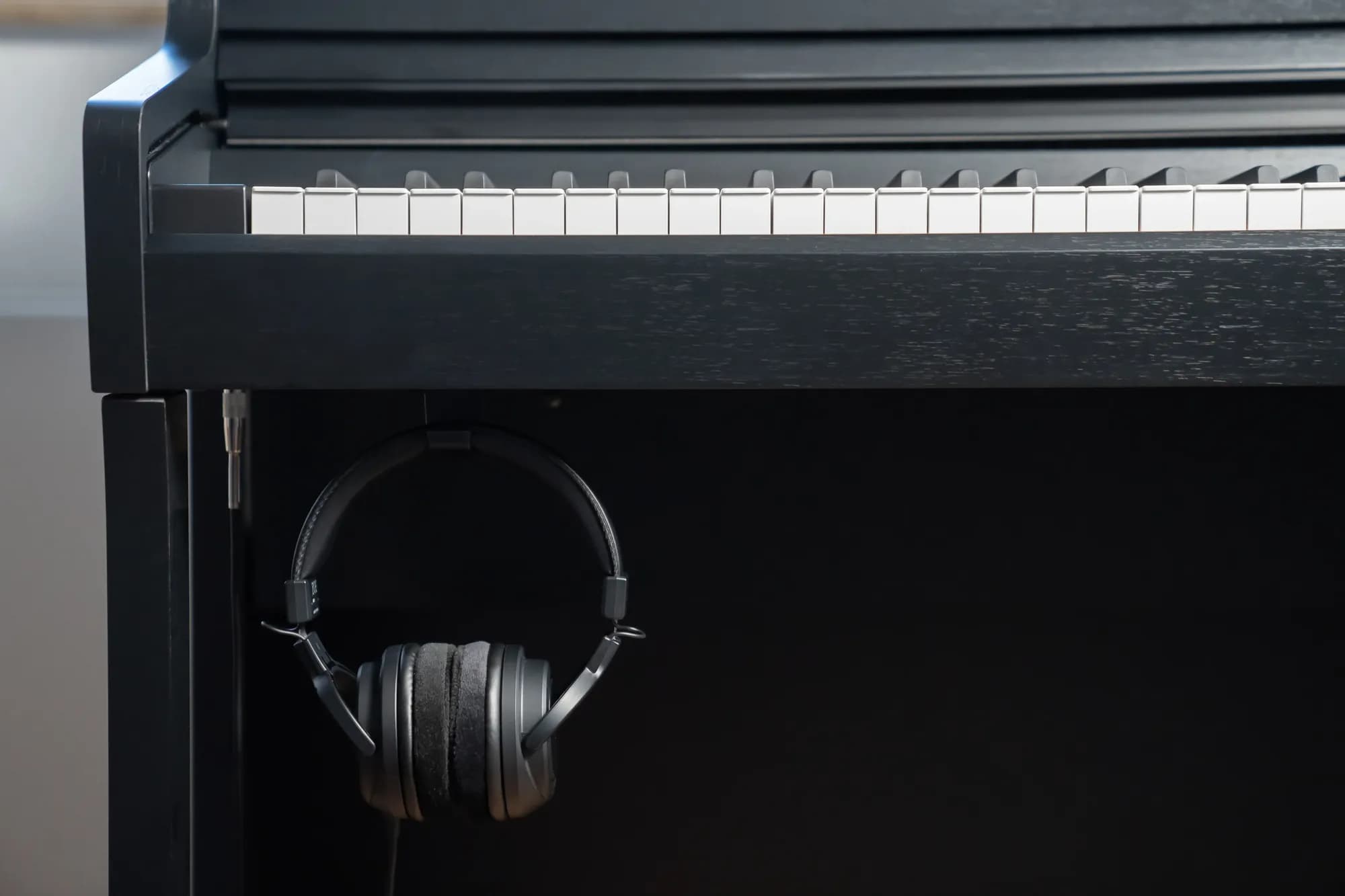 Kawai SH-9 headphones hanging beneath a Kawai CA Series digital piano